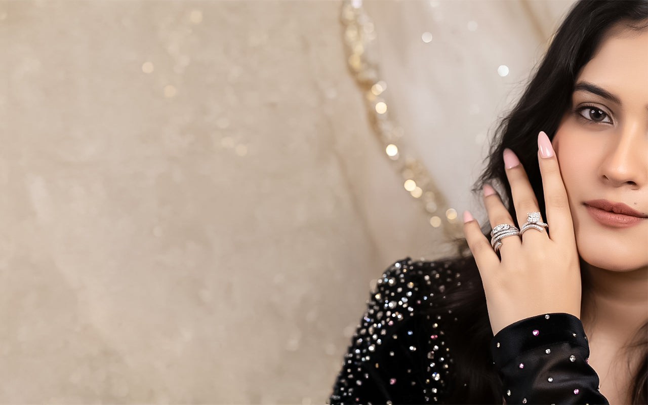 Woman wearing multiple rings on her hand with a neutral background