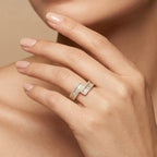 Close-up of a hand wearing a diamond ring on a beige background