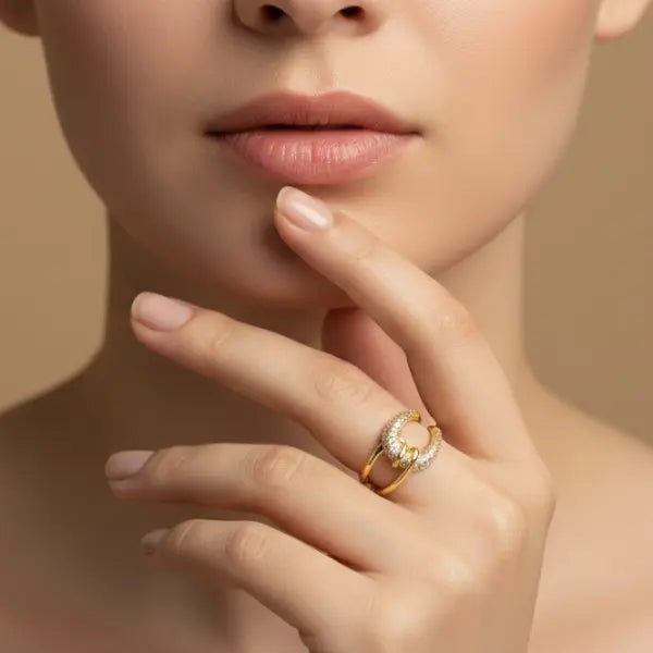 Close-up of a hand wearing a gold ring with a diamond on a beige background