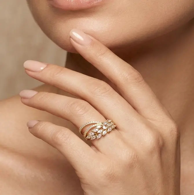Close-up of a hand wearing a rose gold ring with diamonds, touching the face.