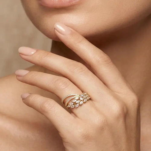 Close-up of a hand wearing a rose gold ring with diamonds, touching the face.
